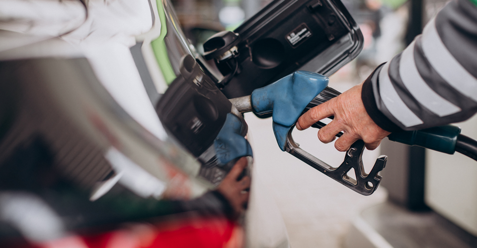 Close-up shot of a gas pump nozzle being inserted into a car's fuel tank