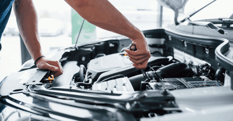 Close-up shot of a fair-skinned man, around 30 years old, working on a car engine.