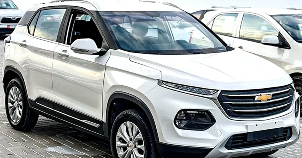 White Chevrolet-Groove compact SUV parked on a paved lot, showcasing sleek design, chrome accents, and modern headlights, conveying a sense of elegance.
