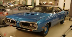 A blue muscle car showcased in a museum, highlighting its sleek design and classic features.