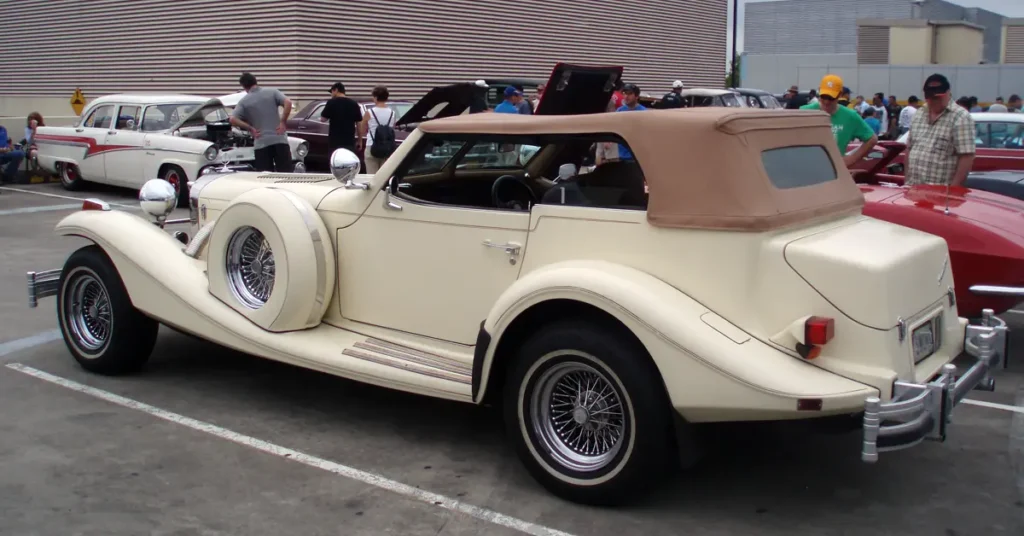 A classic car Excalibur SS (1964) parked in a parking lot, showcasing its vintage design and polished exterior.