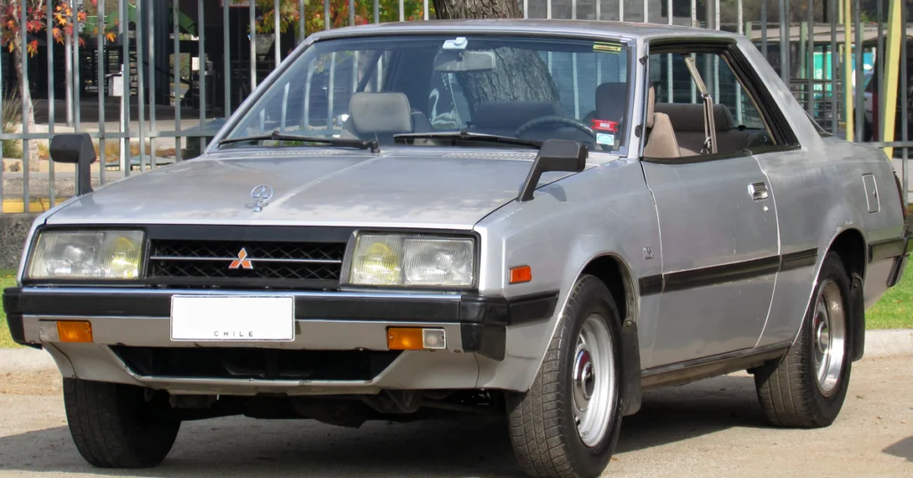 Silver vintage Plymouth Sapporo (1978) car parked outdoors, featuring an angular design with rectangular headlights and a black grille. The mood is nostalgic and classic.