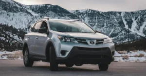 A 2019 Toyota RAV4 parked in a parking lot, surrounded by other vehicles and greenery in the background