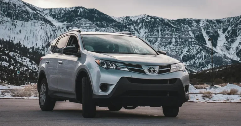 A 2019 Toyota RAV4 parked in a parking lot, surrounded by other vehicles and greenery in the background