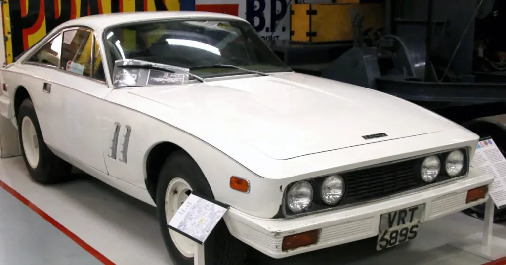 A white Trident Clipper (1965) car on display in a museum, showcasing its design and historical significance to visitors.