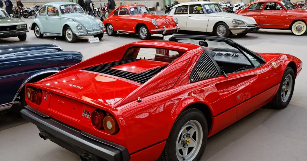 A red sports car parked in a modern showroom, showcasing its sleek design and polished exterior.