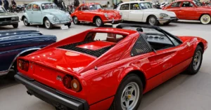 A red sports car parked in a modern showroom, showcasing its sleek design and polished exterior.