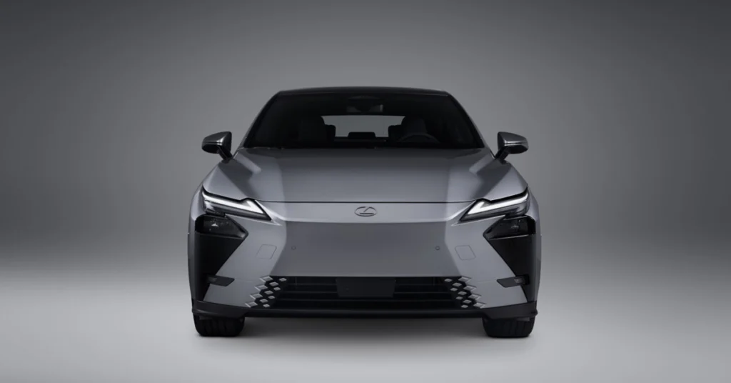 Front view of a gray 2026 Lexus ES Redefined: Luxury Meets Electrification in the Boldest Saloon Evolution Yet with a gray background. The car has a sleek, modern design with sharp lines and a low profile. The headlights are narrow and angular, and the grille is small and understated.