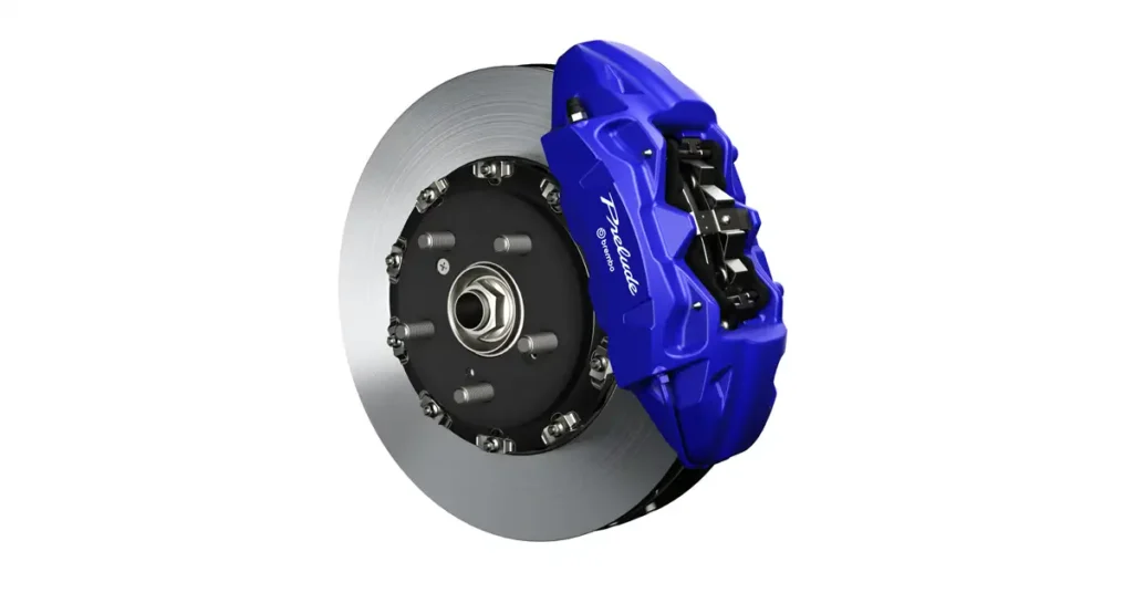 A close-up shot of a 2025 Honda Prelude brake disc and caliper, the disc is silver and has a smooth, metallic surface, with a series of small holes or indentations around the center, the caliper is bright blue and has the word "Prelude" written on it in white letters
