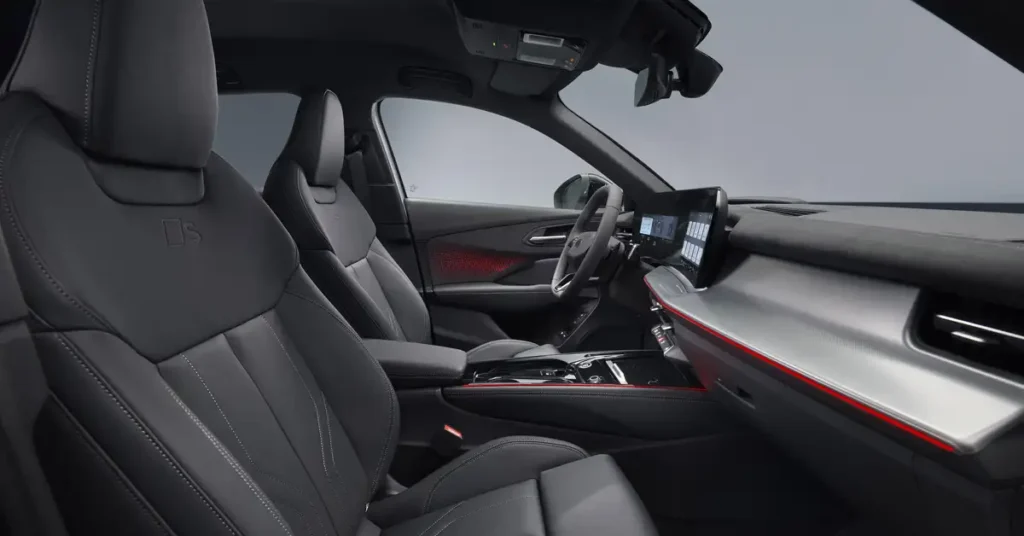 A high-angle, medium shot captures the interior of a New 2025 Audi Q3 car, focusing on the front seats and dashboard. The seats are upholstered in black leather with subtle stitching details, and the headrests are prominently visible.