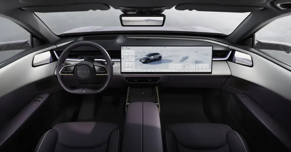Interior of a Mazda EZ-60 , featuring a minimalist design with a focus on technology and comfort. The dashboard is dominated by a large, wide-screen display that spans the majority of the console, showing a car image.