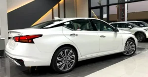 A pristine white Nissan Altima SV, captured from a rear three-quarter perspective, stands out with its sleek design and modern features.