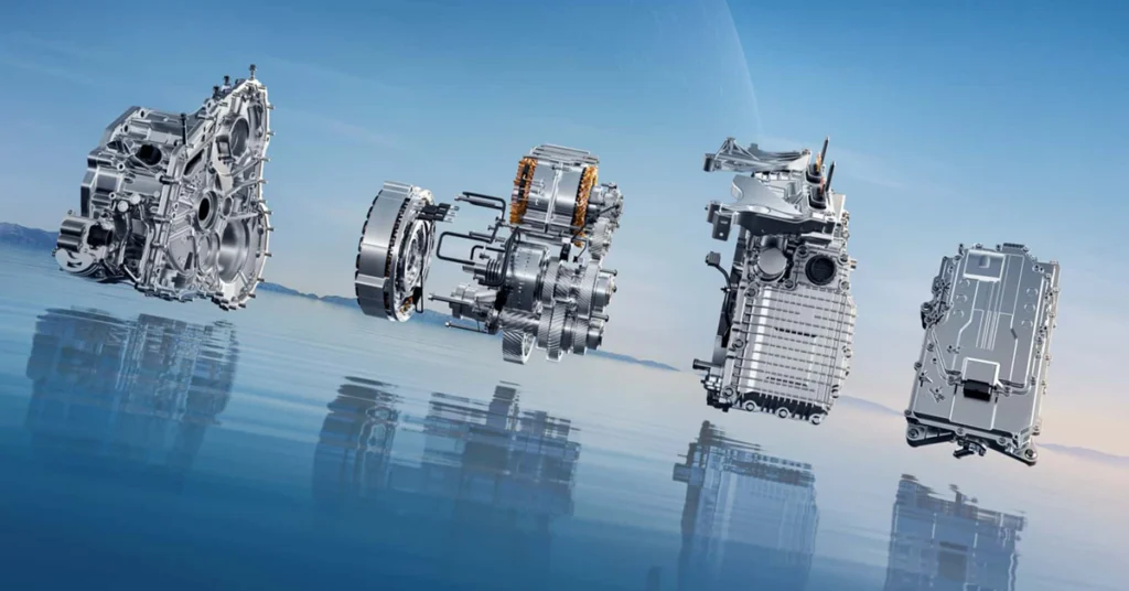 A digital rendering of an exploded view of an electric vehicle powertrain, set against a backdrop of a blue sky and water. The powertrain components are arranged in a row, from left to right, with each part meticulously detailed to showcase its internal structure and design.