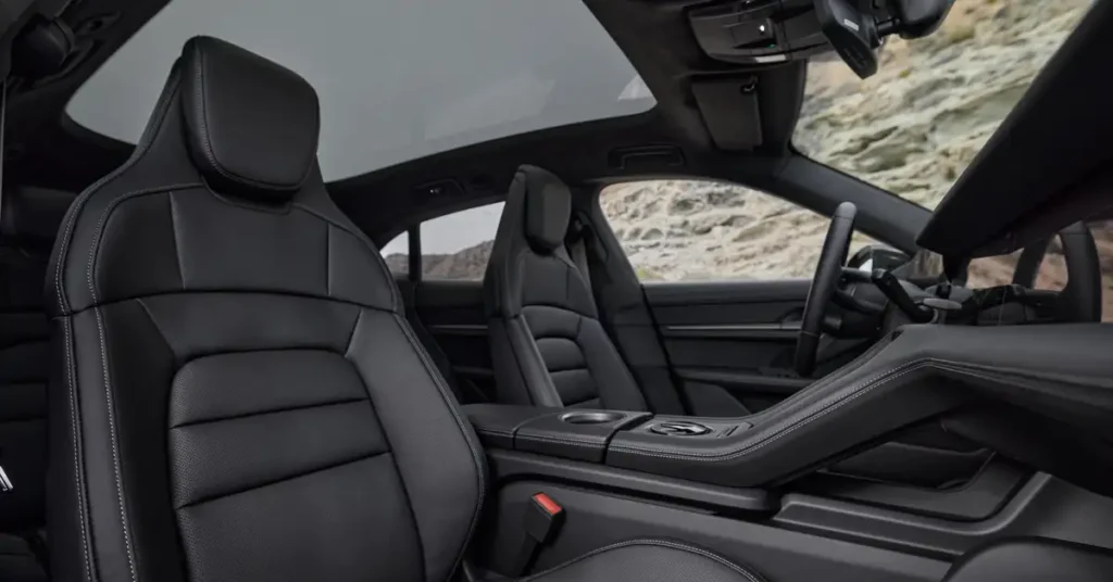 A photograph shows the interior of a Porsche Taycancar with black leather seats and a panoramic sunroof.