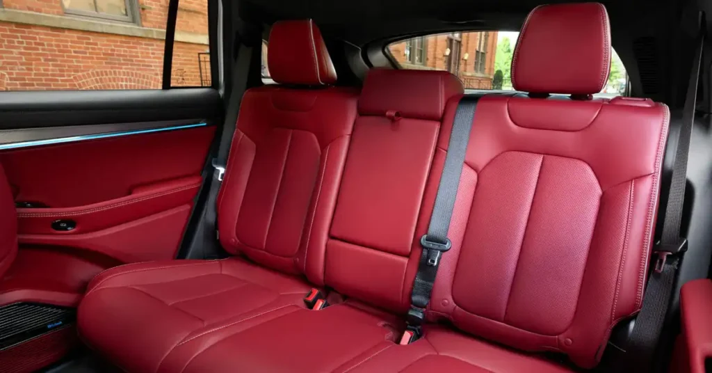 A close-up shot of the interior of 2025 Jeep Wagoneer S , focusing on the back seats. The seats are upholstered in a vibrant red leather, with a smooth texture and subtle sheen. The design of the seats is modern and ergonomic, featuring defined contours and stitching that accentuates their shape. 