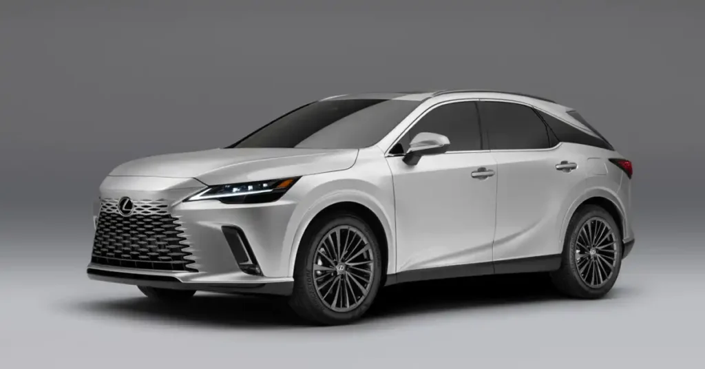 A silver 2025 Lexus RX 350 is shown in a studio shot against a plain gray background. The SUV is angled to the left, with its front end facing the viewer. The car has a sleek, modern design with sharp lines and a prominent spindle grille