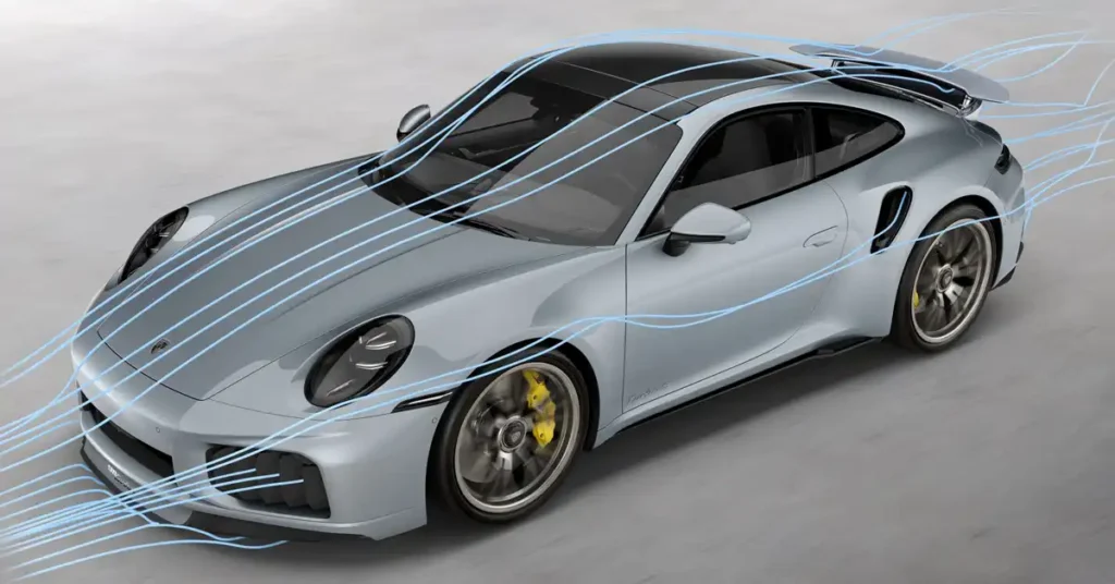 A silver Porsche 911 Turbo S is shown from a high-angle, three-quarter front view, with light blue lines illustrating airflow around the car. The car has a black panoramic sunroof and tinted windows. The front bumper has large air intakes,