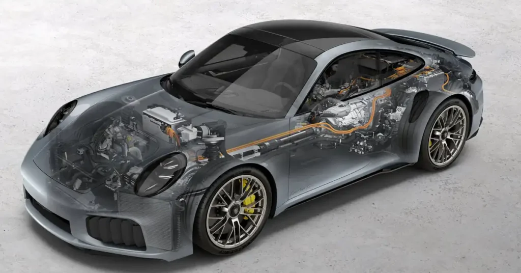 A transparent gray Porsche 911 Turbo S is shown in a studio setting. The car is a 2020 model, and its interior components are visible through the transparent body. The engine, transmission, and other mechanical parts are exposed, revealing the car's internal workings.