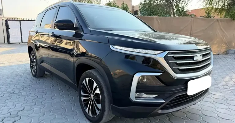 A black Chevrolet Captiva SUV is parked on a paved driveway. The car is facing the viewer at a slight angle, with its front right side most prominent. The SUV has a sleek, modern design with chrome accents around the grille and headlights. The grille features horizontal slats and the Chevrolet logo in the center. The headlights are slim and angular, with integrated LED daytime running lights.