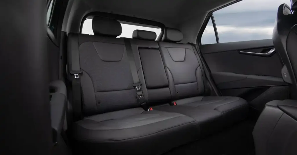 The image shows the rear seats of a 2026 Kia Niro Hybrid SUV. The seats are upholstered in dark gray and black leather with a textured fabric insert on the backrests.