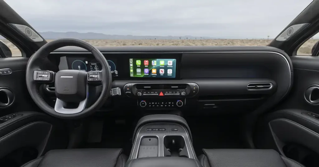 The image shows the interior of a 2026 Hyundai Palisade, focusing on the dashboard and steering wheel. The dashboard features a large, wide touchscreen display showing various app icons, a digital instrument cluster behind the steering wheel, and a central console with climate controls and a gear selector.