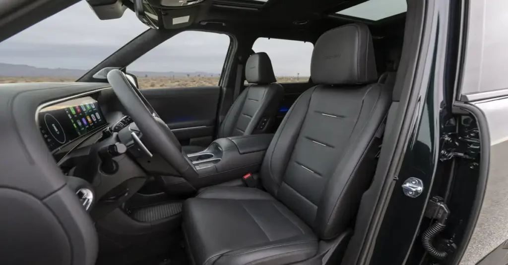The image shows the interior of a 2026 Hyundai Palisade, focusing on the front passenger seat and dashboard. The seats are upholstered in black leather with a quilted pattern and contrast stitching. The dashboard features a large, sleek touchscreen display showing various app icons.