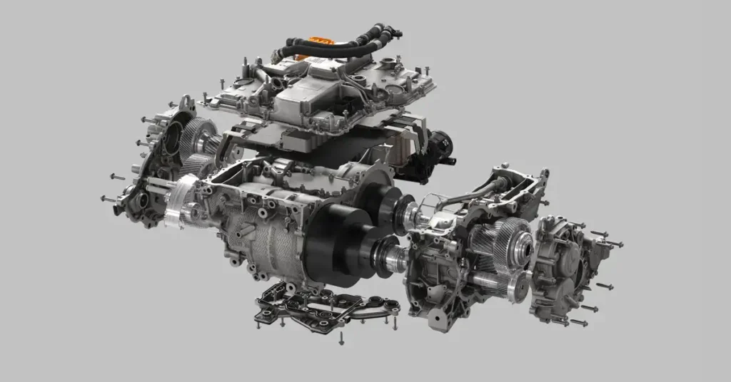 An exploded view of an A BMW M 3 powertrain is presented against a plain gray background. The main subject is a complex assembly of metallic components, including gears, casings, motors, and wiring harnesses, all meticulously separated to reveal their internal structure.